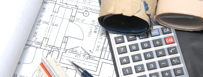a calculator and pen on a blueprint